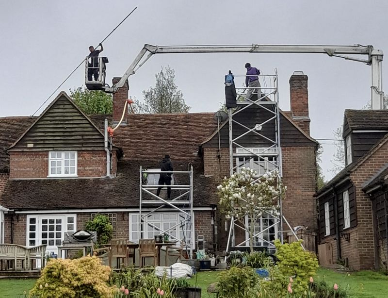 The Roof Moss Cleaners using cherry picker and scaffolding to clean roof safely and professionally in Henfield, West Sussex